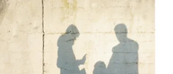 Eine Familie wird als Schatten auf eine Betonwand geworfen.