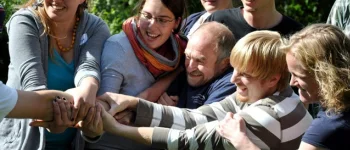 viele lachende Menschen ziehen zusammen an einem Arm