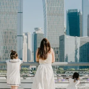 Familie steht an einem Geländer vor einer Skyline