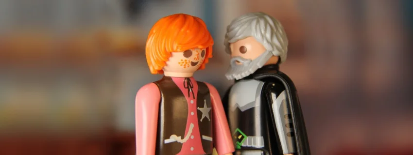 Zwei Playmobil-Figuren, eine jung, die andere alt, stehen sich sich gegenüber