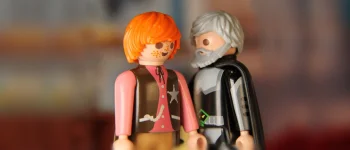 Zwei Playmobil-Figuren, eine jung, die andere alt, stehen sich sich gegenüber