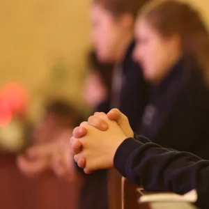 Betende Menschen in einer Kirchenbank.