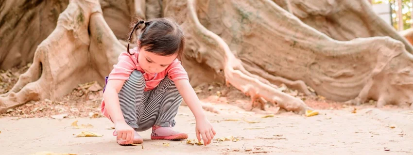 Tief verwurzelt. Wie Kinder an Krisen wachsen können. Bild von einem spielenden Kind.