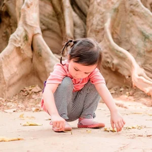 Tief verwurzelt. Wie Kinder an Krisen wachsen können. Bild von einem spielenden Kind.